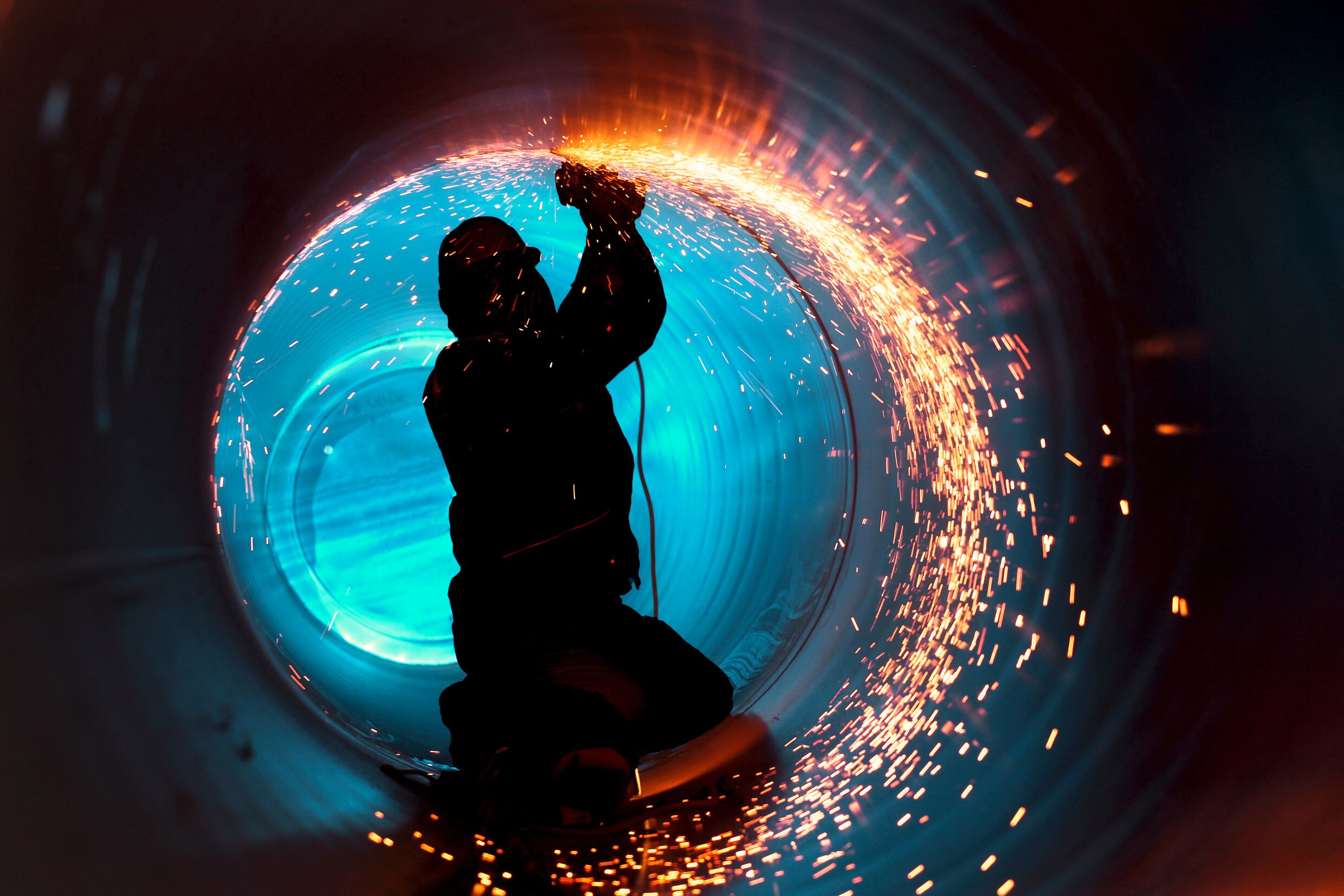 Medium A5 RGB web-A worker works inside a pipe on a pipeline construction.jpg